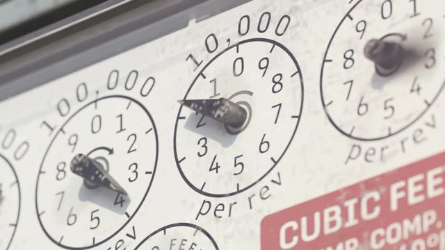 Mechanical flow meter dials with rotating pointers and cubic feet