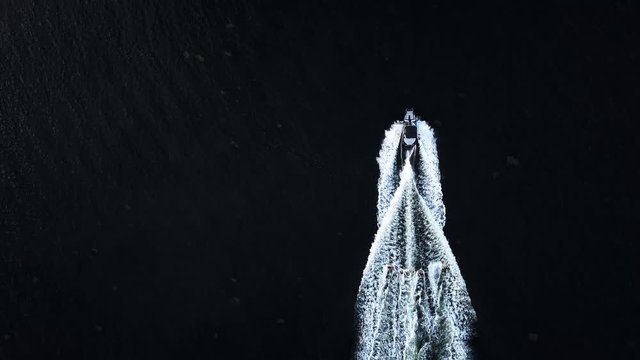 Water sports 5 people discing behind boat birds eye view