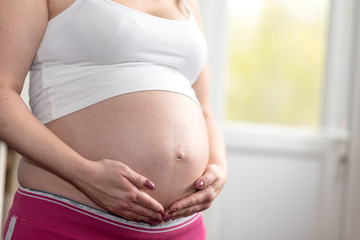 Pregnant woman with hands on her belly