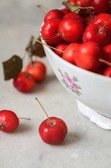 Small paradise apples in a beautiful bowl on a marble background.