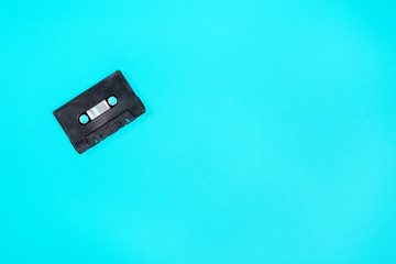 Fototapeta premium Retro black plastic audio cassette laying on the green metal table