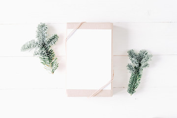 Elegant christmas clean minimal modern composition with gift box, present. Christmas decor, pine cones, fir branches on wooden white background. Flat lay, top view, copy space