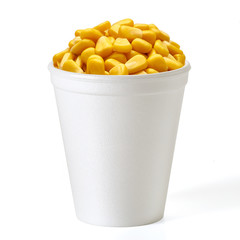 Boiled corn kernels in foam cup side view isolated on white background.