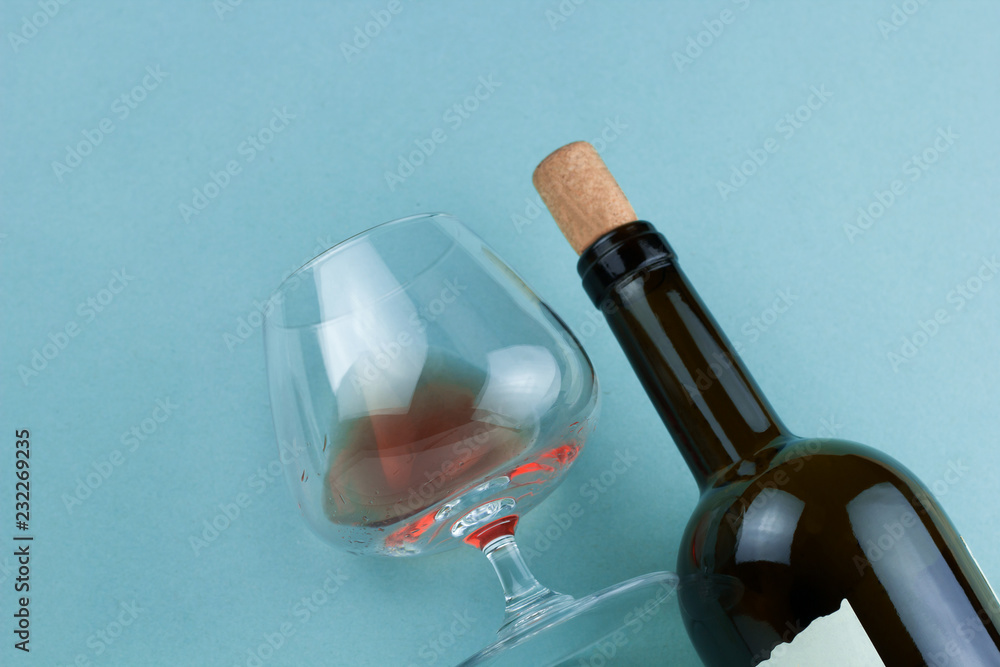 Wall mural Bottle of wine and wineglass with red wine top view  on blue background