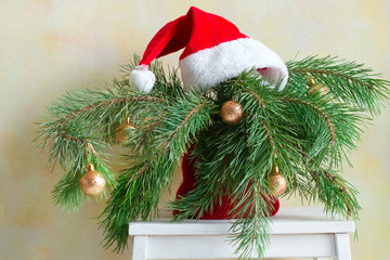 Christmas tree branches in a pot on a chair, home holidays decor