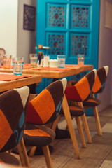 empty room interior in blue and orange colors, served table and chairs