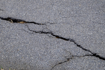 Old worn and cracked asphalt with cracks