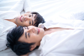 Obraz na płótnie Canvas Sweet and cute shot of gay couple relaxing on bed, love and relationships concept, selective focus