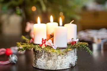 Advent candles on the birch pole with traditional wooden ornaments and spruce twigs.