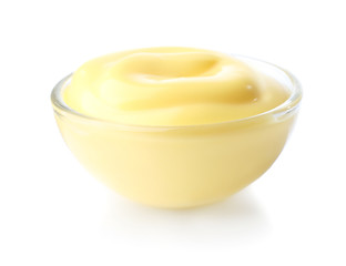 Tasty yellow sauce in glass bowl on white background