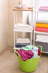 Laundry basket with dirty clothes in bathroom