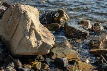 Sea stones and rocks of different sizes and texsture of black, gray and brown on the Black Sea coast as nature bacground. Excellent concept for any design