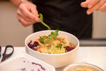 hand of a cook preparing a colorful healthy dish