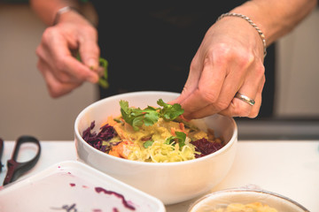 hand of a cook preparing a colorful healthy dish