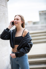 Fototapeta premium Teenage girl talking on mobile phone happy
