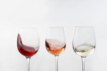 Glasses of different wine on white background