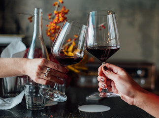 Toasting glasses with red wine