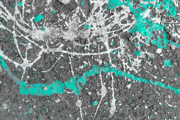 a gray wall with stains of blue paint, scratches and holes