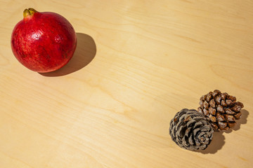 winter fruits and vegetables on a wooden floor. Pomegranate, pumpkin, persimmon and pine cones. Christmas and winter holidays.