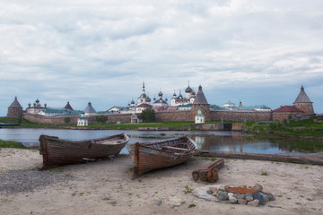 Fototapeta na wymiar Two old wooden boats on the background of the Solovetsky Monastery, Russia