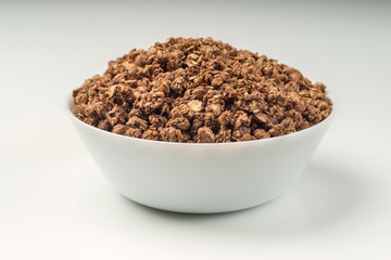 Granola breakfast on a bowl over white background
