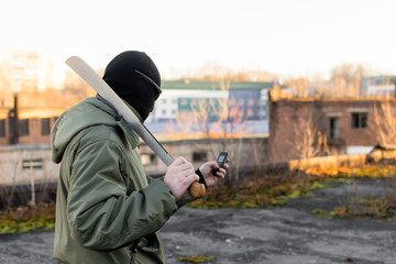 Terrorist with a machete looks into the phone - obrazy, fototapety, plakaty