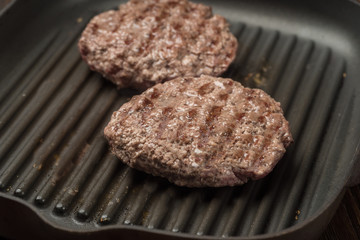 Food: fried homemade burger on a frying pan.