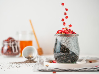 Healthy breakfast concept and idea - two colors chia pudding with organic raw pomegranate. Glass...
