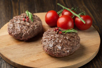 Freshly grilled burger meat ion wooden cutting board.
