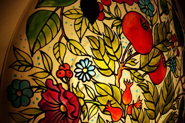 Colorful round hand-painted glass lamp with stained glass paints, with a floral pattern with leaves...