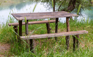 Wooden bench with a table by the lake