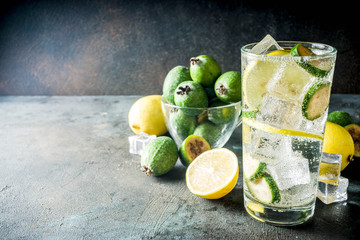 Iced feijoa lemonade on dark blue concrete background copy space
