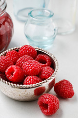 Bowl of raspberries and red jam.