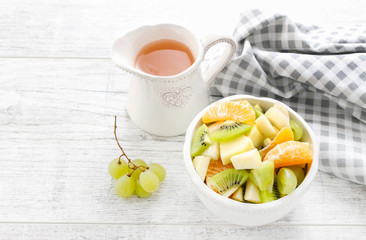 Bowl of fruit salad and jug of juice.