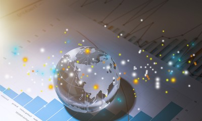 Glass globe ball in light rays on background of business charts