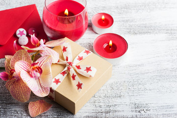 Orchids, craft gift box and lit candles