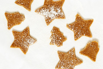Christmas Gingerbread Cookies, Stars, bells, Christmas tree from sweet dough on white paper for baking