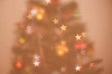 Defocused Christmas tree, colorful star shaped bokeh, Christmas background.