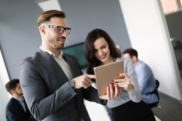 Happy business colleagues in modern office talking