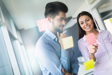 Businesswoman using sticky notes at office to plan project