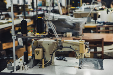 selective focus of sewing machine and strings at workshop