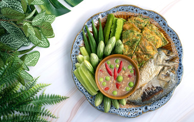 Thai Shrimp Paste Chilli Dipping Sauce (Nam Prik Kapi) with fresh vegetables , fried fish and fried climbing wattle, acacia, Cha-om in fried eggs