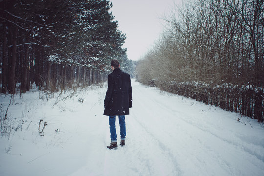 Portrait of young man walking in feald during snow storm