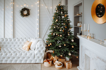 Christmas decor. Bright interior of the living room with large  elegant Christmas tree with toys...