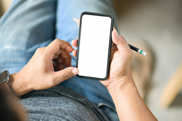 Top view shot of man holding pencil and using mobile phone