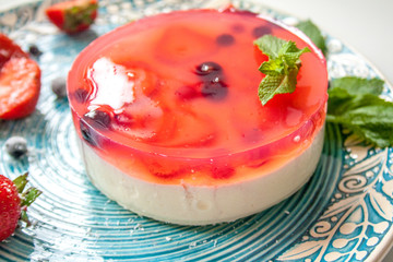 cottage cheese pie with strawberries, mint and frozen blueberries on a plate