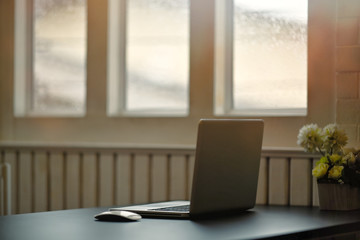 Laptop with office supplies and gadgets on wooden table