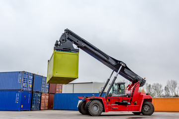 Reach-Stacker carrying a yellow container