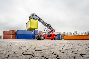 Reach-Stacker carrying a yellow container