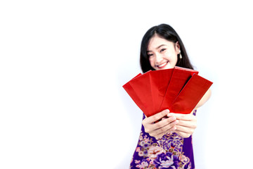 An Asian girl in Cheongsam or Qipao dress is smiling and happy emotion to you in Chinese New Year festival concept.